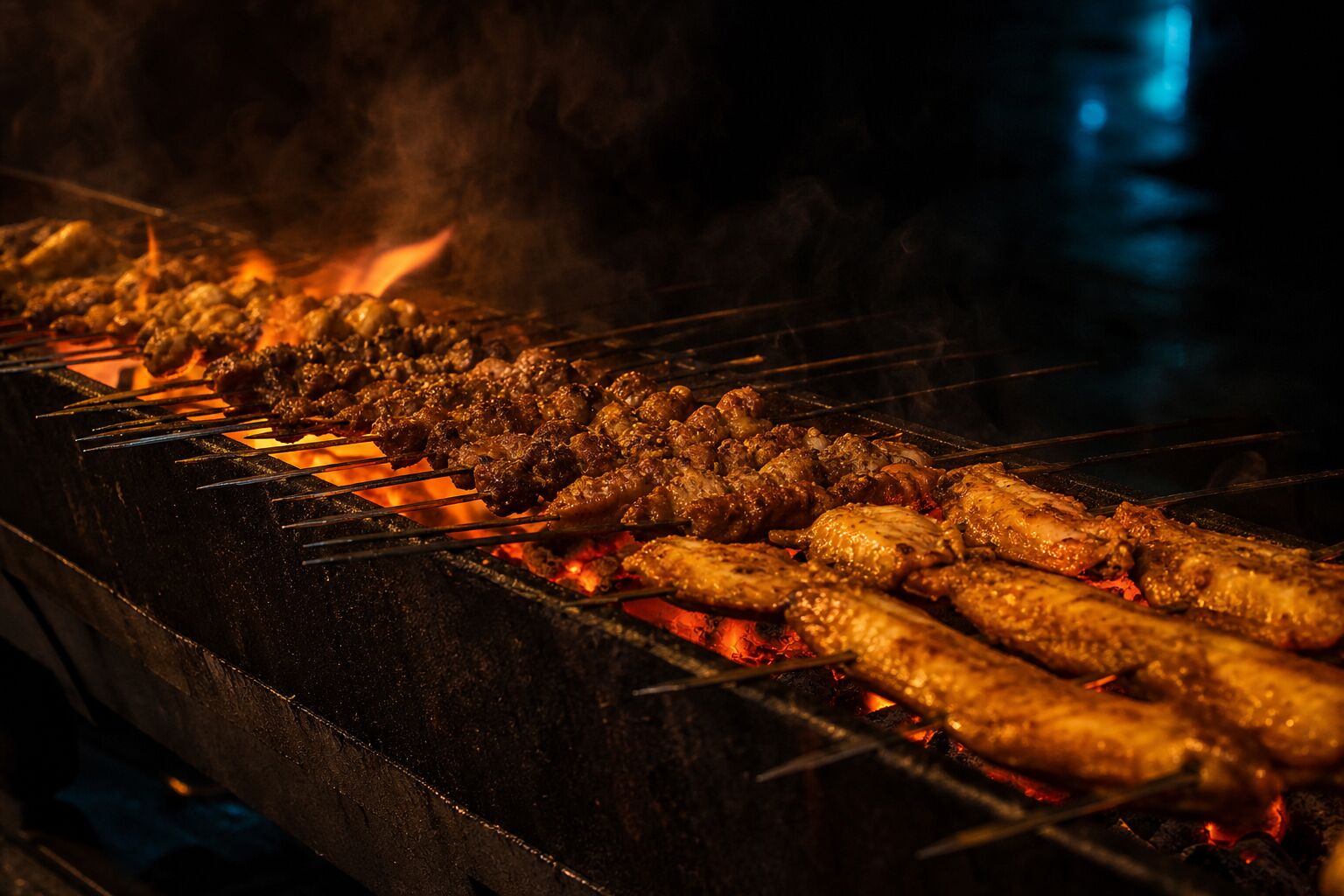 Rows of skewers over glowing charcoal